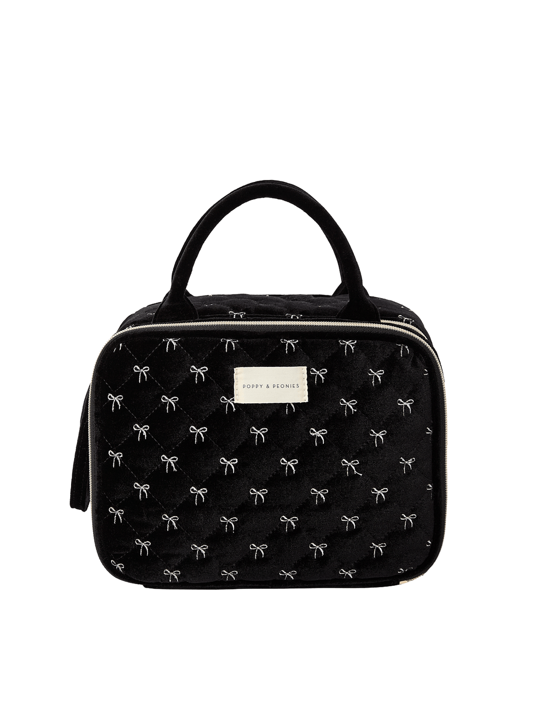 Poppy and Peonies The Routine Cosmetic Black Velvet featuring a structured rounded rectangular silhouette, soft black velvet exterior with delicate white bow patterns, dual black top handles, zip-around closure, and rectangular gold Poppy and Peonies logo plate on the front.