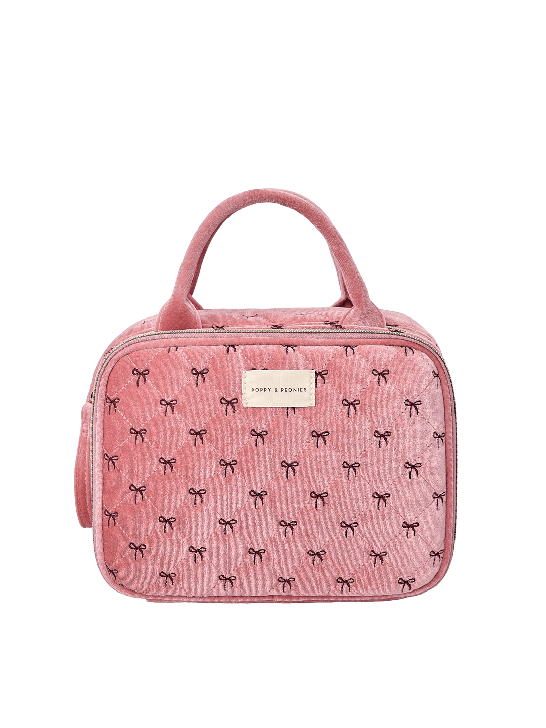 Poppy and Peonies The Routine Cosmetic Pink Velvet featuring a structured rounded rectangular silhouette, soft pink velvet exterior with delicate black bow patterns, dual pink top handles, zip-around closure, and rectangular gold Poppy and Peonies logo plate on the front.