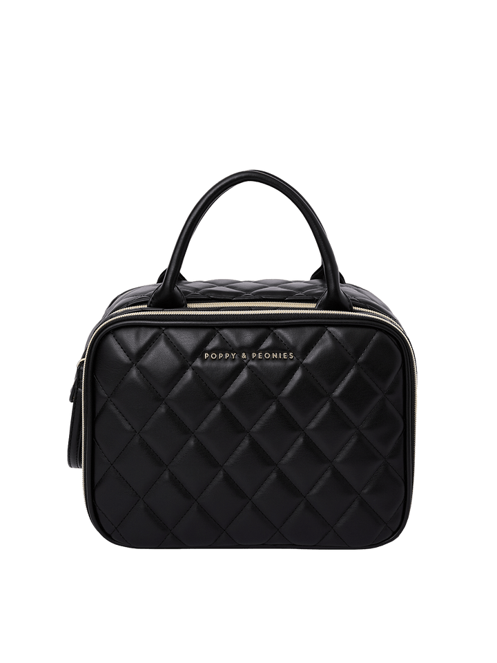 Poppy and Peonies The Routine Cosmetic Black featuring a structured rounded rectangular silhouette, black diamond-quilted exterior, dual black top handles, zip-around closure, and gold Poppy and Peonies logo on the front.