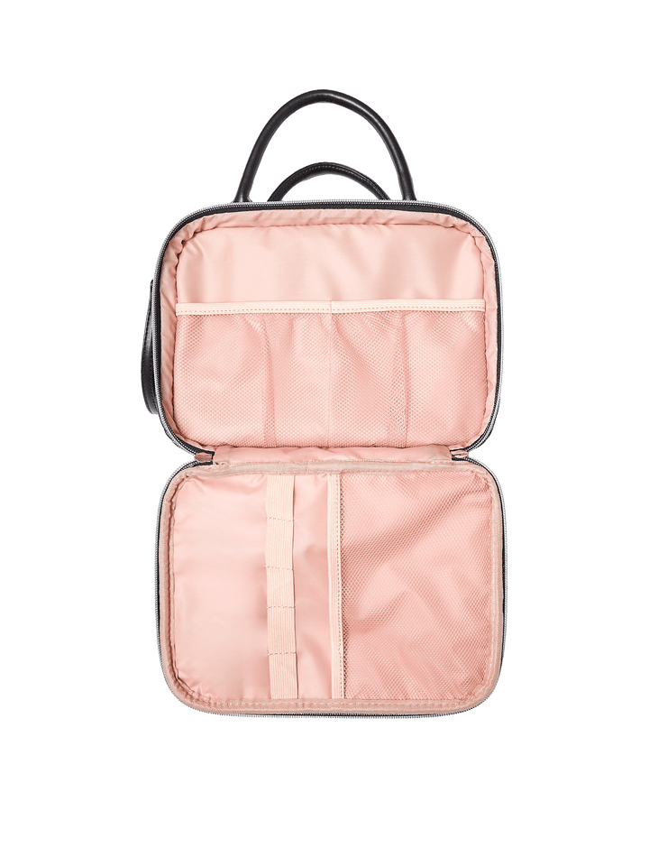 Poppy and Peonies The Routine Cosmetic Black displayed fully open, showcasing its blush pink interior with elastic storage pockets, a central organizing strap, and spacious compartments for cosmetics and toiletries.