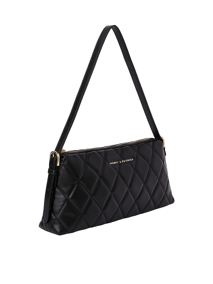 Poppy and Peonies The Soho Shoulder Bag Quilted Black displayed at a three-quarter angle, highlighting its sleek rectangular profile, black diamond-quilted exterior, slim shoulder strap, and gold-tone hardware.