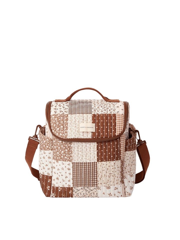 Poppy & Peonies The Lunch Date in Brown Patchwork with top handle, front flap, side pockets, and adjustable shoulder strap.