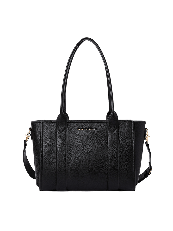 Poppy and Peonies Small Multitasker Black featuring a structured rectangular silhouette, textured black exterior, dual shoulder handles, detachable adjustable shoulder strap, gold-tone hardware, vertical seam detailing, and subtle Poppy and Peonies logo on the front