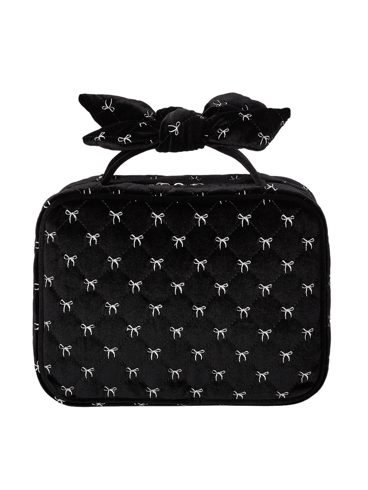 Poppy and Peonies Hook Me Up Cosmetic Case Black Velvet displayed from the back, showcasing its soft black velvet exterior with delicate white bow patterns, structured rectangular silhouette, decorative bow-shaped top handle, and zip-around closure.