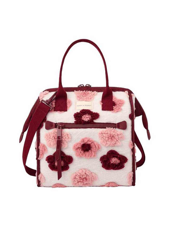 Poppy and Peonies The Lunch Bag Berry Floral featuring a structured rectangular silhouette, cream-colored exterior with pink and berry floral patterns, contrasting berry trim, dual top handles, detachable shoulder strap, gold-tone hardware, and front zippered pocket.