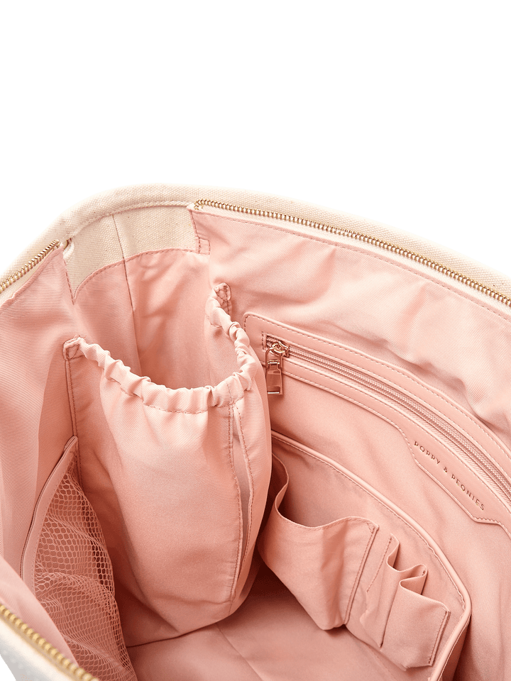 Interior detail of Poppy & Peonies The Signature Tote in Olive, featuring blush pink elasticated bottle holders, a zippered pocket and gold-tone zipper.
