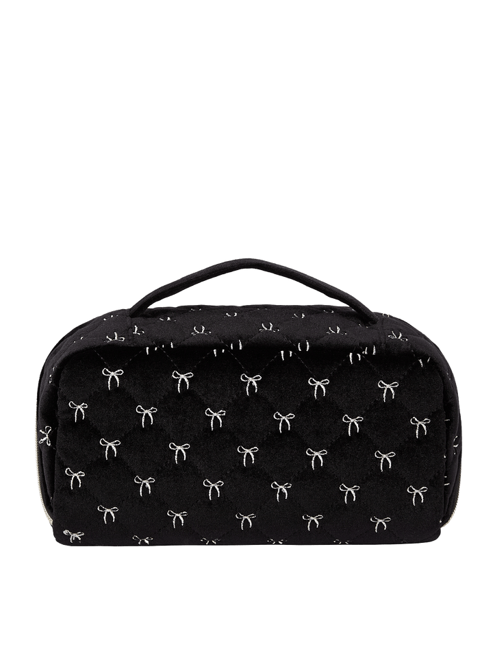 Poppy and Peonies Open and Glow Cosmetic Case Black Velvet displayed from the back, featuring its soft black velvet exterior with delicate white bow patterns, structured rectangular silhouette, top carrying handle, and zippered closure.