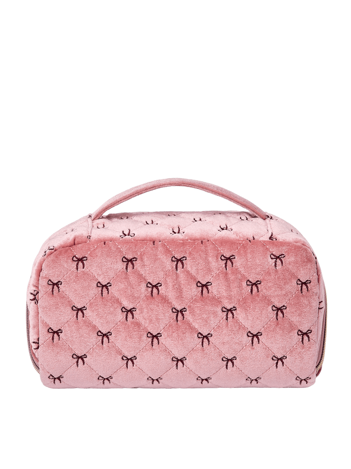 Poppy and Peonies Open and Glow Cosmetic Case Pink Velvet displayed from the back, featuring its soft pink velvet exterior with delicate black bow patterns, structured rectangular silhouette, top carrying handle, and zippered closure.