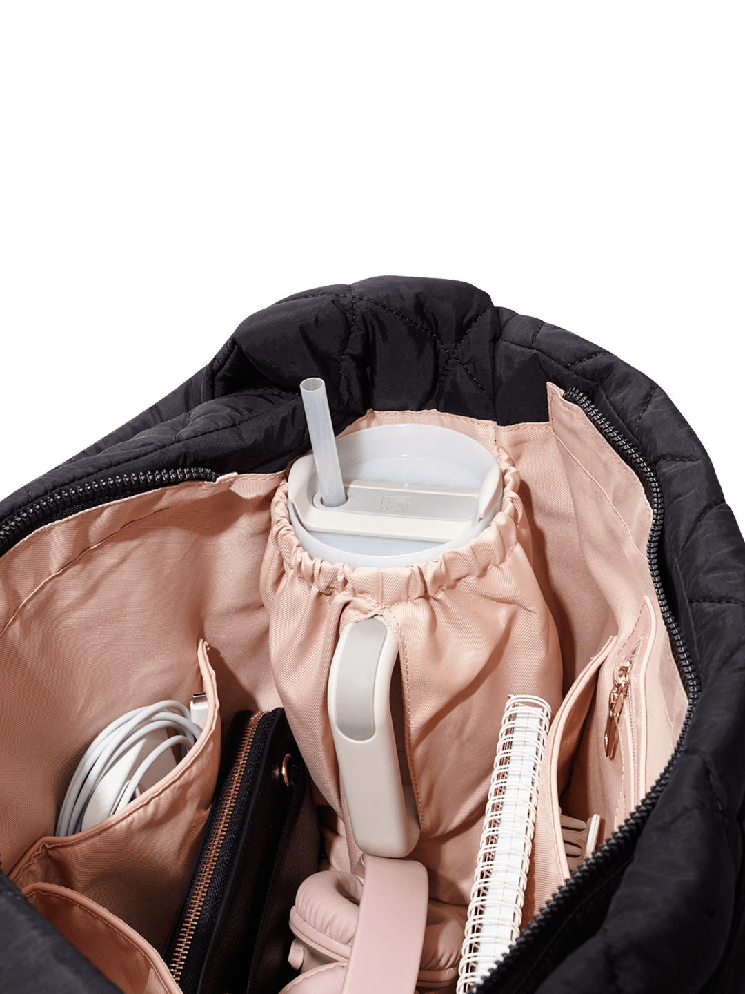 Close-up of a black quilted hand bag with a pink interior.