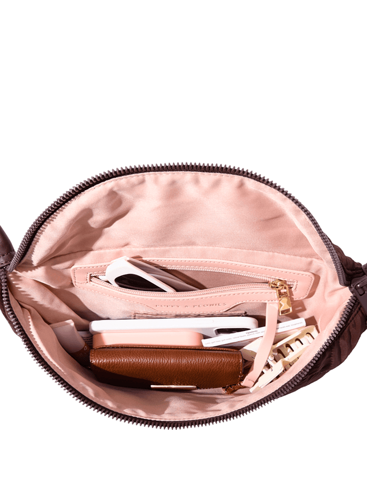 Open handbag with various items on a transparent background
