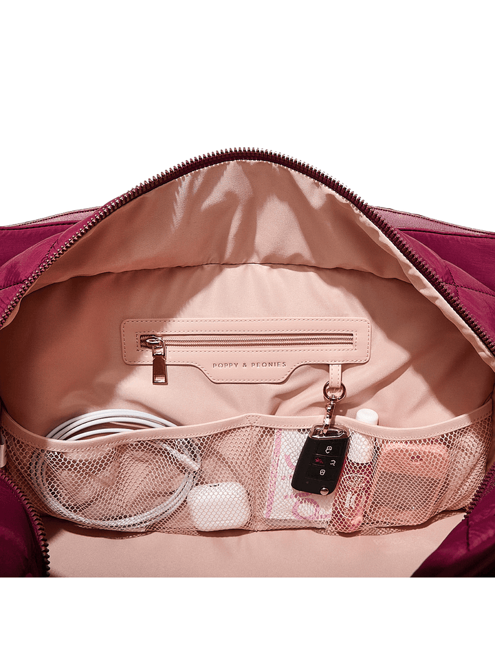 Open berry coloured travel bag with organized compartments.
