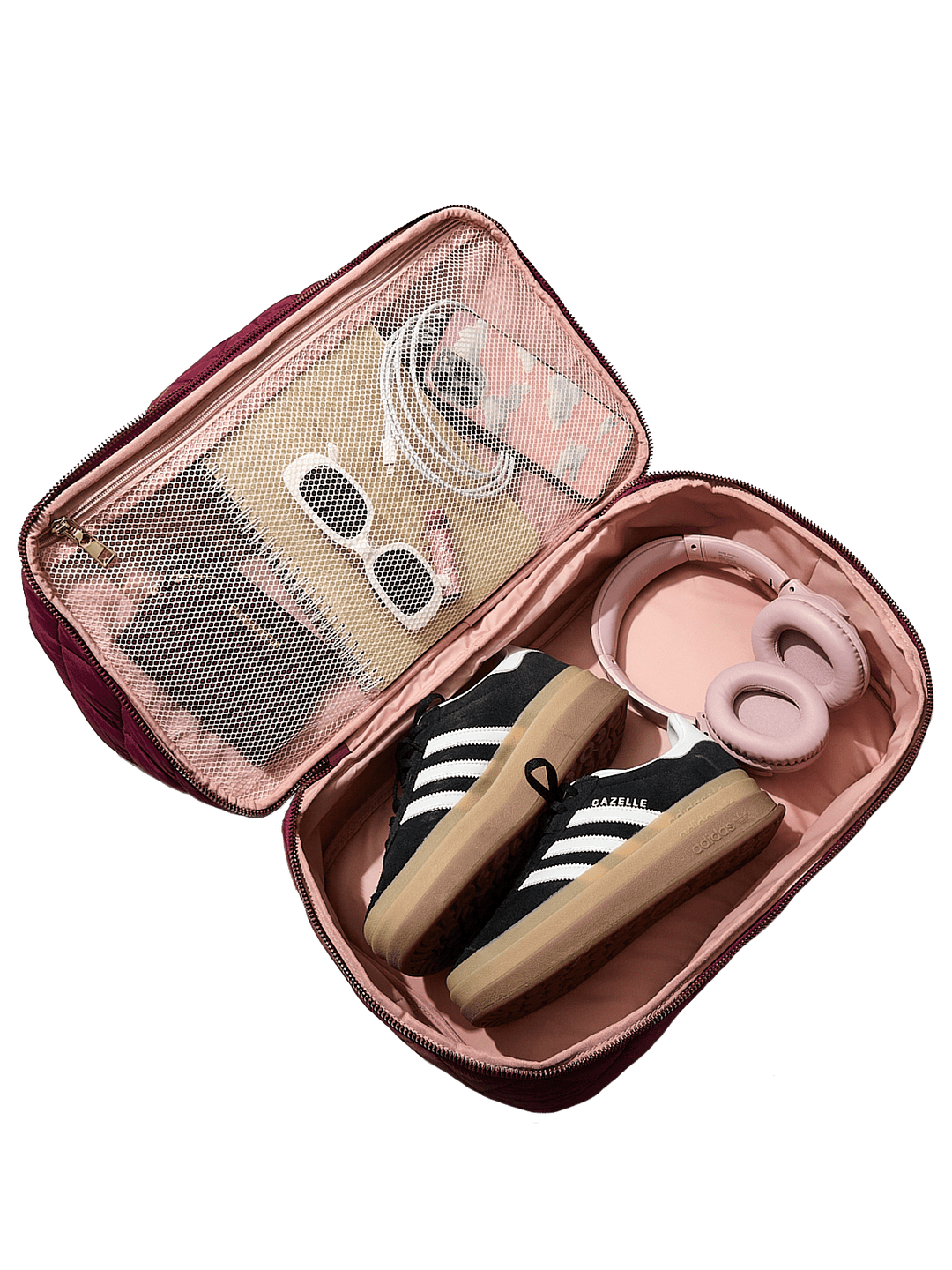 Berry coloured travel bag with a sneaker, sunglasses, and other items on a transparent background
