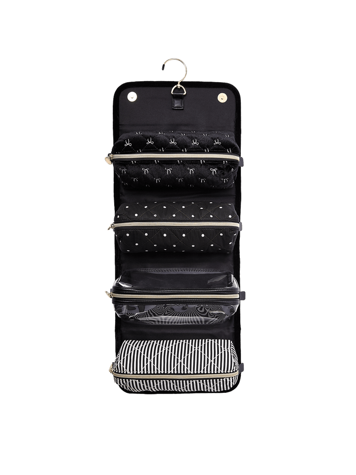 Poppy and Peonies The Glam Squad Cosmetic Case Black Velvet displayed fully unfolded and hanging vertically, revealing multiple black storage compartments, zippered sections, and a black and white striped bottom pocket for organizing beauty essentials.