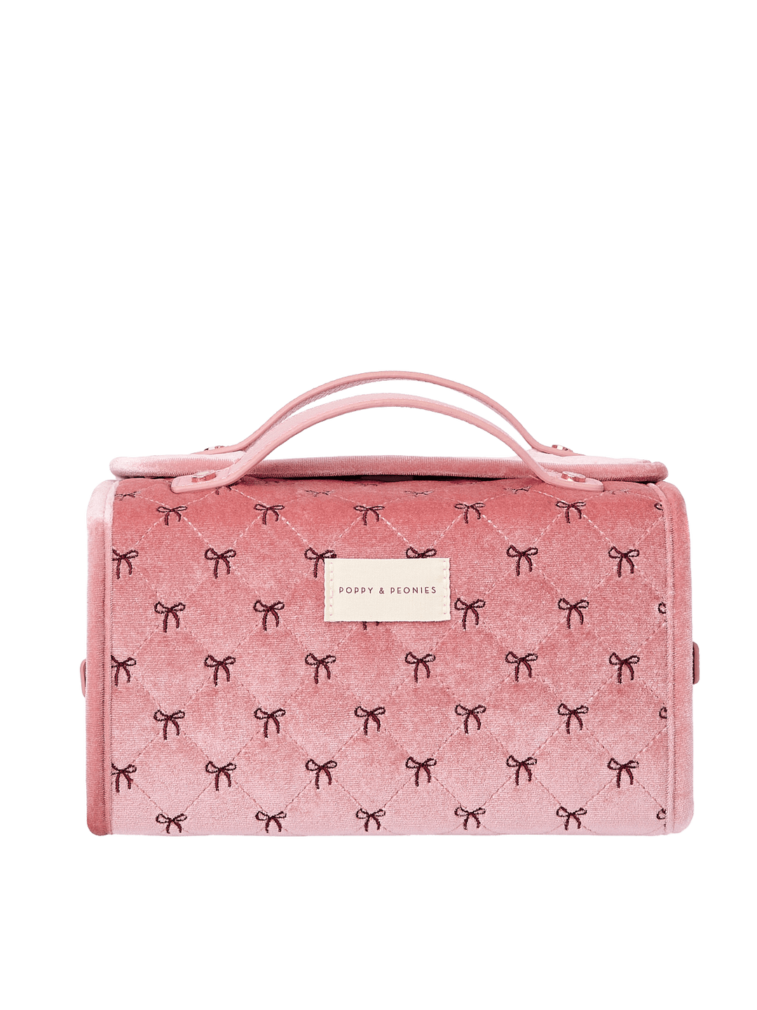 Poppy and Peonies The Glam Squad Cosmetic Case Pink Velvet featuring a structured rectangular silhouette, soft pink velvet exterior with delicate black bow patterns, dual top handles, zip-around closure, and rectangular gold Poppy and Peonies logo plate on the front.