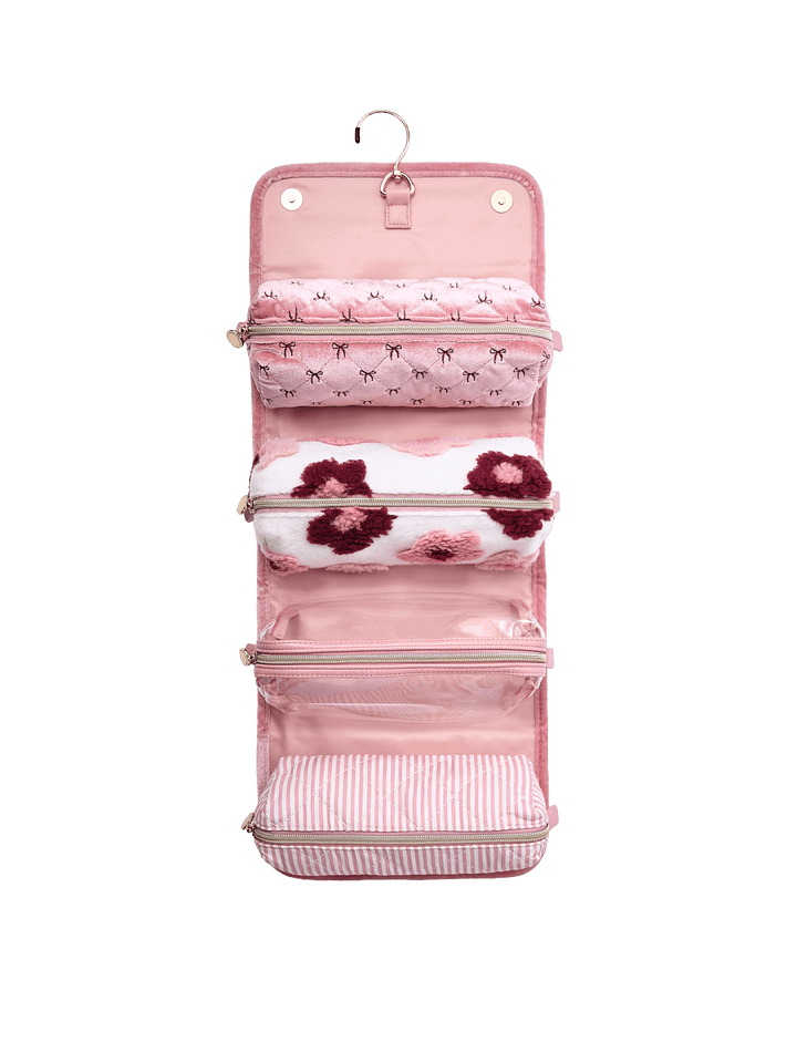 Poppy and Peonies The Glam Squad Cosmetic Case Pink Velvet displayed fully unfolded and hanging vertically, revealing multiple blush pink storage compartments, zippered sections, and coordinating floral and striped patterns for organizing beauty essentials.