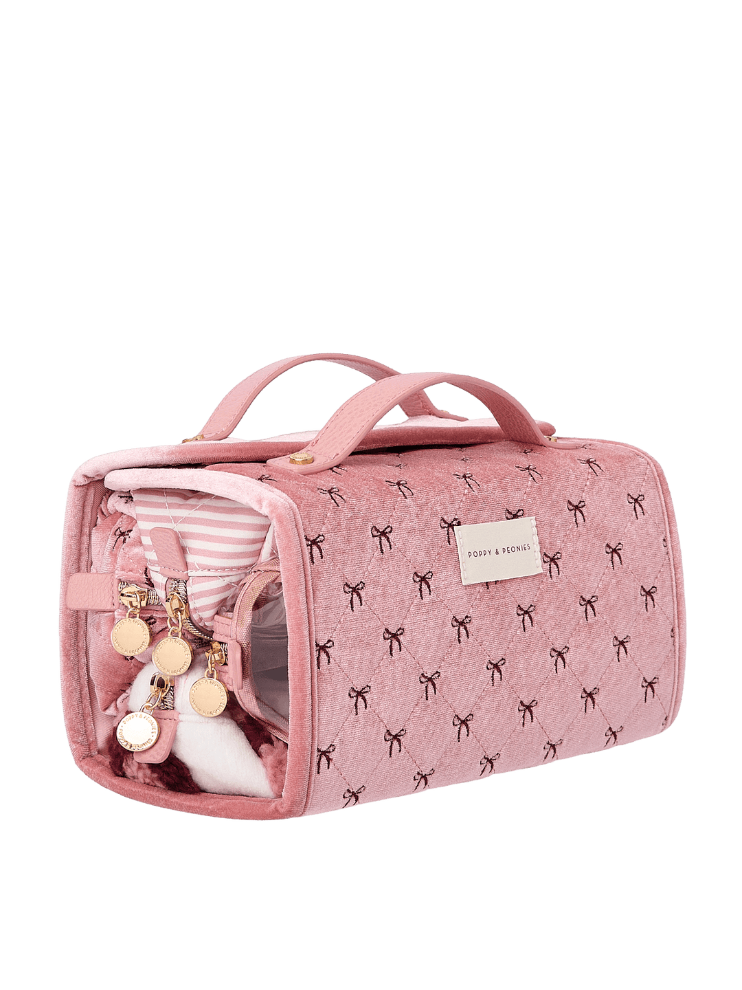 Poppy and Peonies The Glam Squad Cosmetic Case Pink Velvet displayed at a three-quarter angle with its side compartment open, highlighting its pink velvet exterior with black bow patterns, structured rectangular shape, dual top handles, and organized interior filled with beauty essentials.