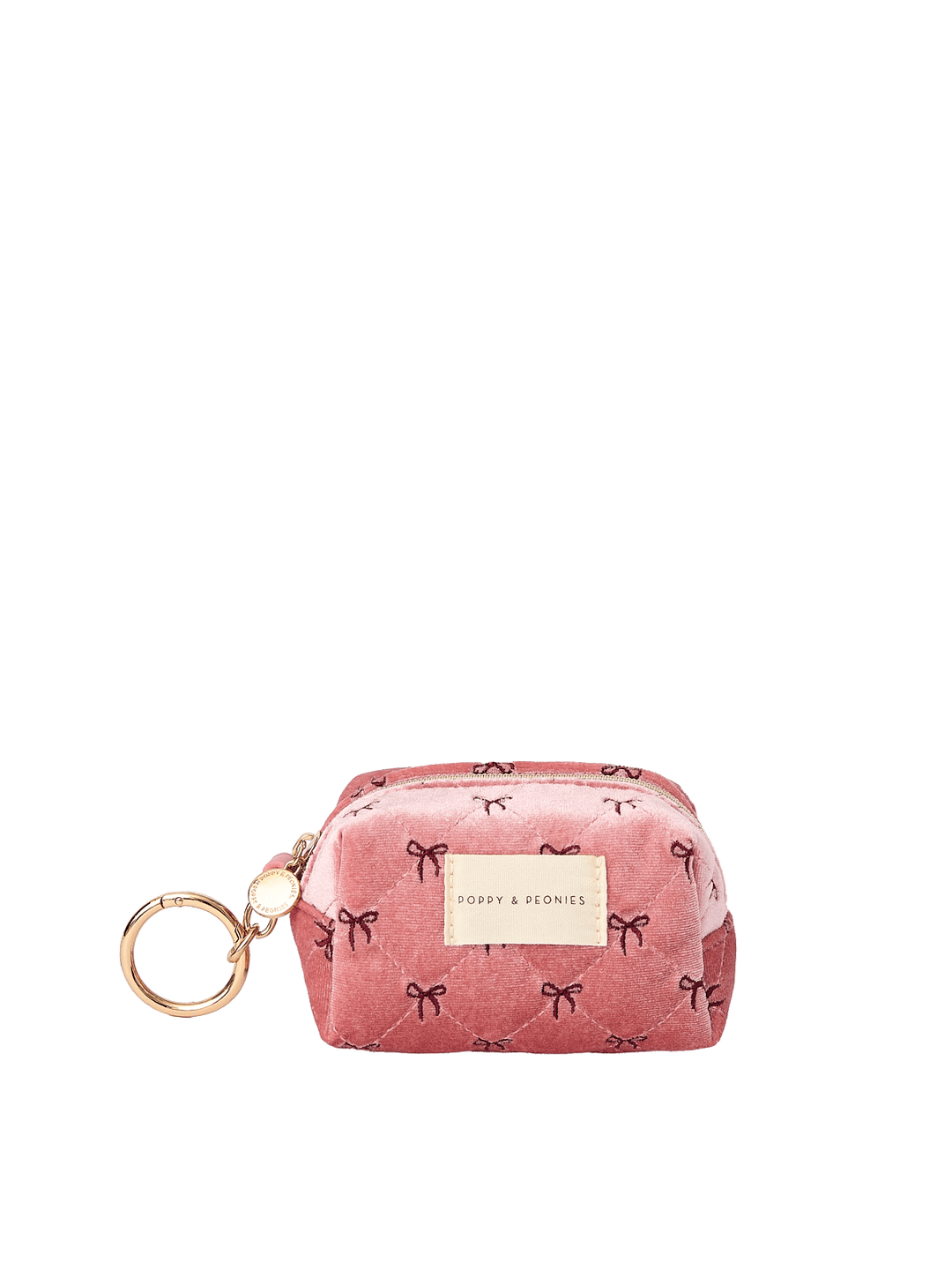 Poppy and Peonies Tag Along Charm Pink Velvet featuring a compact rounded pouch with a soft pink velvet exterior, delicate black bow patterns, gold-tone zipper closure, gold keyring attachment, and rectangular gold Poppy and Peonies logo plate on the front.