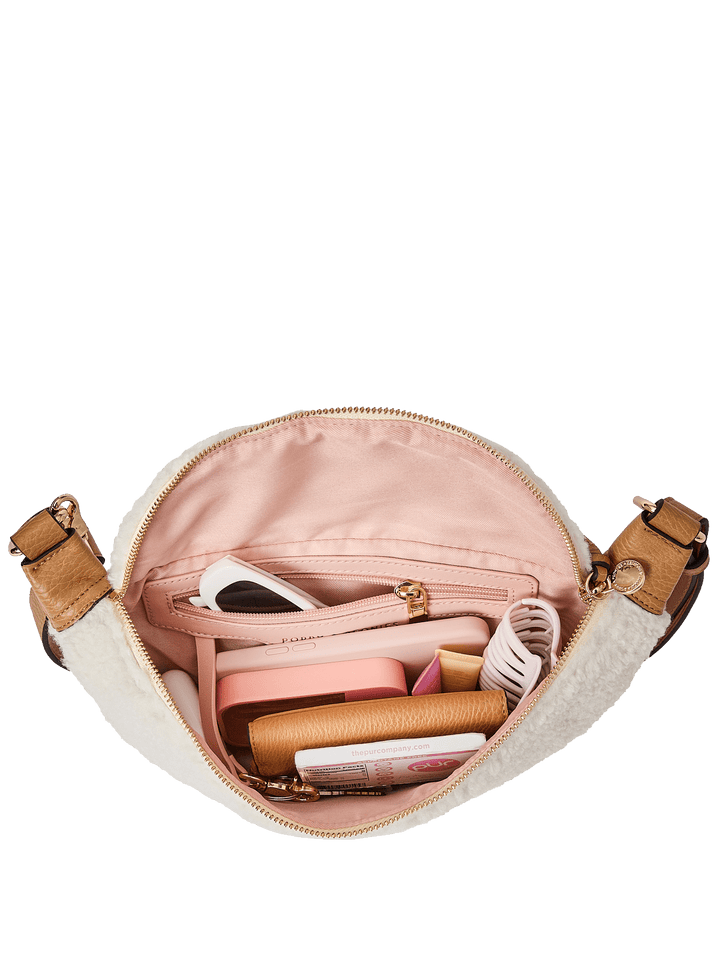 Open faux fur handbag with pink interior showing various items 