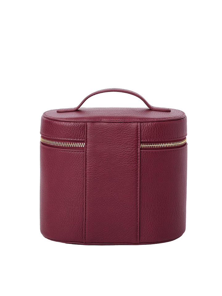 Poppy and Peonies The Vanity Case Berry displayed from the back, featuring its rich berry textured exterior, structured rounded silhouette, top carrying handle, vertical seam detailing, and horizontal gold-tone zipper closure.