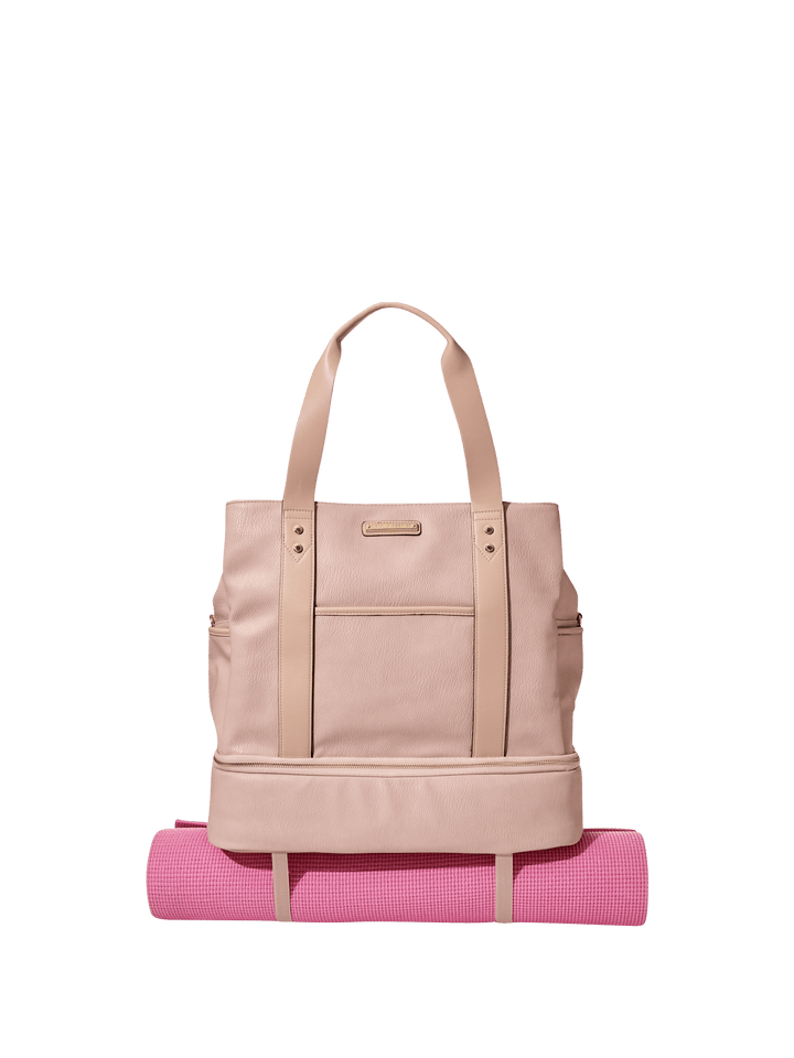 Blush coloured vegan leather travel bag with a pink yoga mat attached to the bottom