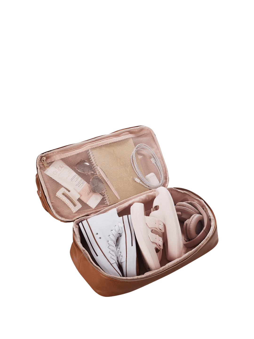 Open compartment on a travel bag with white sneakers and other items