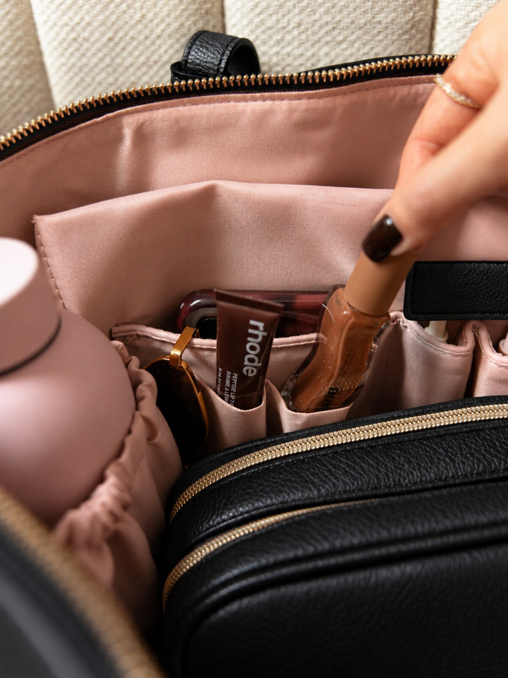 Poppy & Peonies The Knot Tote in Black, close-up of the blush-pink interior featuring organizational pockets, a zippered compartment, and small accessories.