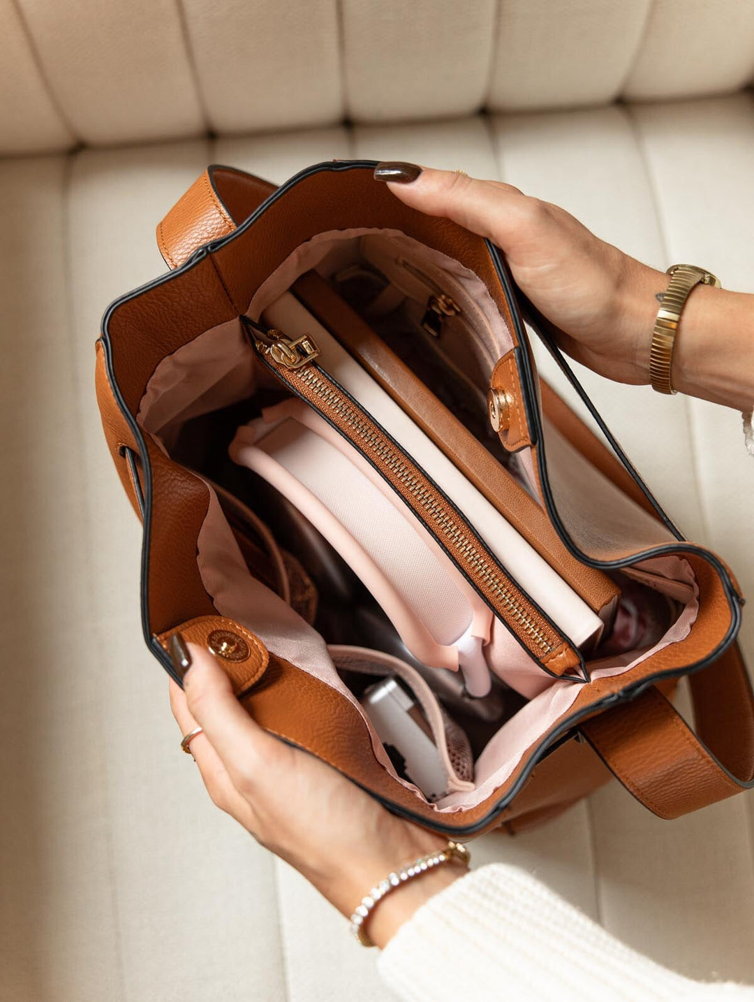 Poppy & Peonies The Knot Shoulder Bag in Cognac, overhead view showing the open interior with blush-pink lining, zippered organizer, and everyday essentials.