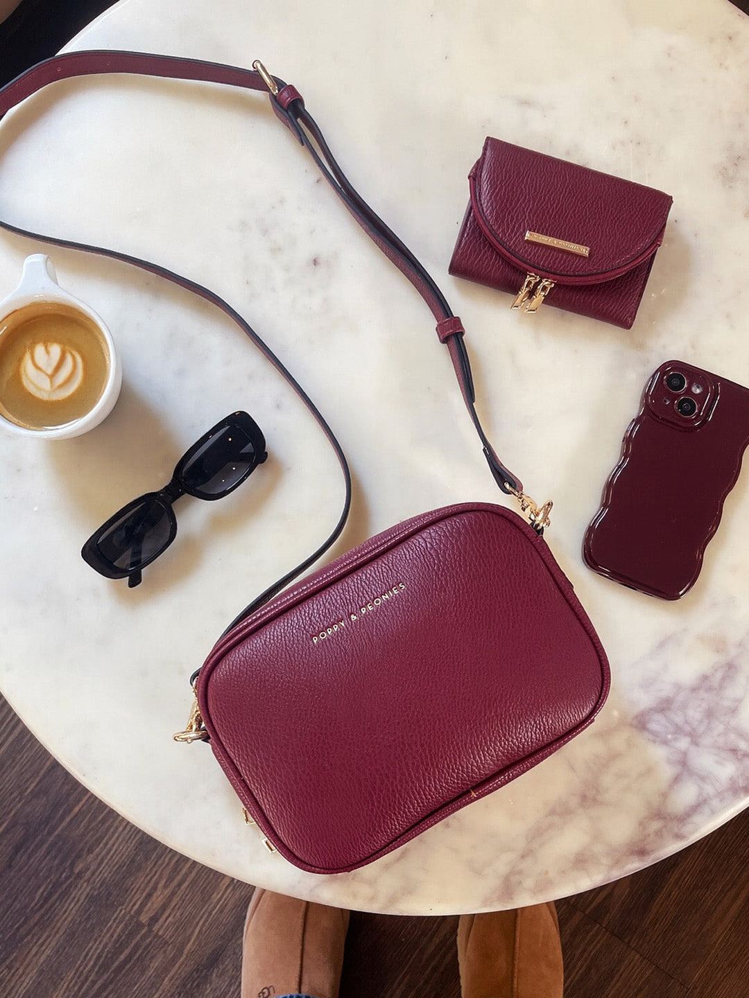 Berry coloured vegan leather bag with matching wallet on a table